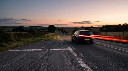 Route de campagne au crépuscule symbolisant le dépassement d'un forfait kilométrique en location de voiture